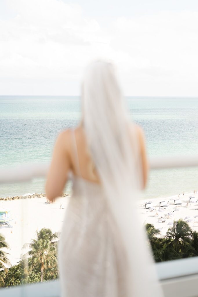 Bride standing on hotel patio with beach views